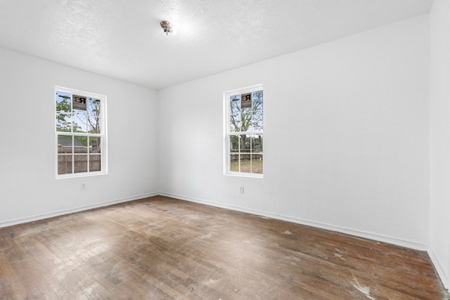 unfurnished room with wood finished floors and baseboards