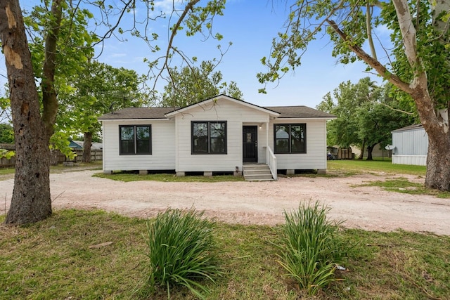 view of front of home with driveway and a shingled roof