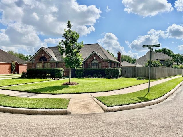 view of front of home featuring a front lawn, fence, and brick siding