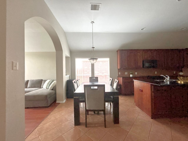 4326 Sunlit Pass Loop, Humble, TX 77396 - dining area with light tile patterned floors, visible vents, vaulted ceiling, and arched walkways