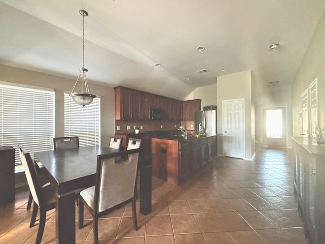 4326 Sunlit Pass Loop, Humble, TX 77396 - dining space with dark tile patterned floors, vaulted ceiling, and baseboards