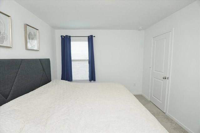 bedroom featuring light carpet and baseboards
