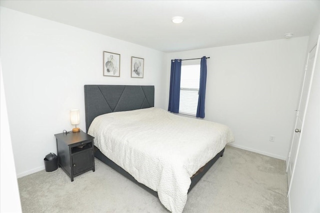 bedroom featuring baseboards and light carpet