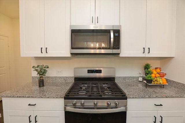 kitchen with white cabinets, stainless steel appliances, and light stone countertops
