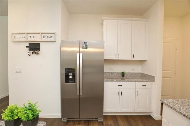 kitchen with baseboards, white cabinets, stainless steel fridge, and dark wood finished floors