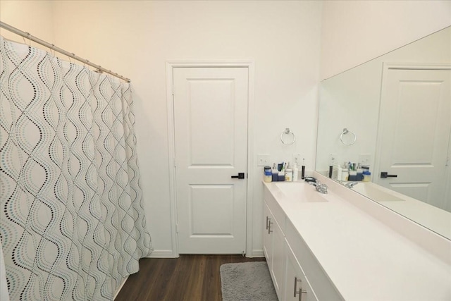 full bathroom featuring wood finished floors, vanity, a shower with shower curtain, and baseboards