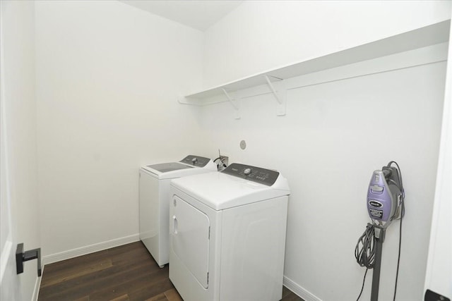 washroom with dark wood-type flooring, baseboards, laundry area, and washing machine and dryer