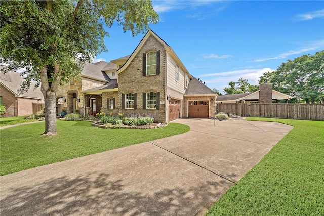 traditional home with brick siding, fence, driveway, and a front yard