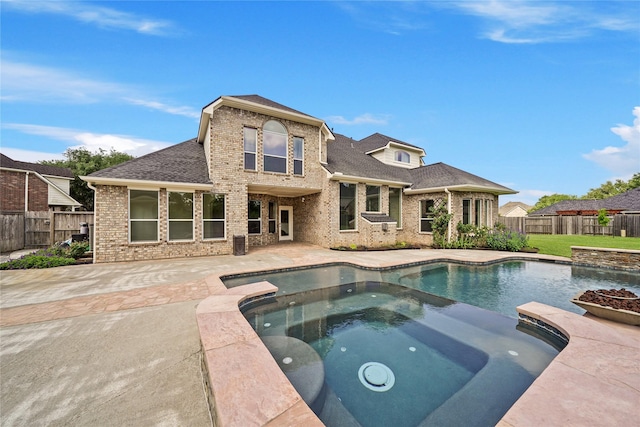 back of property featuring a fenced backyard, roof with shingles, brick siding, a patio area, and a pool with connected hot tub