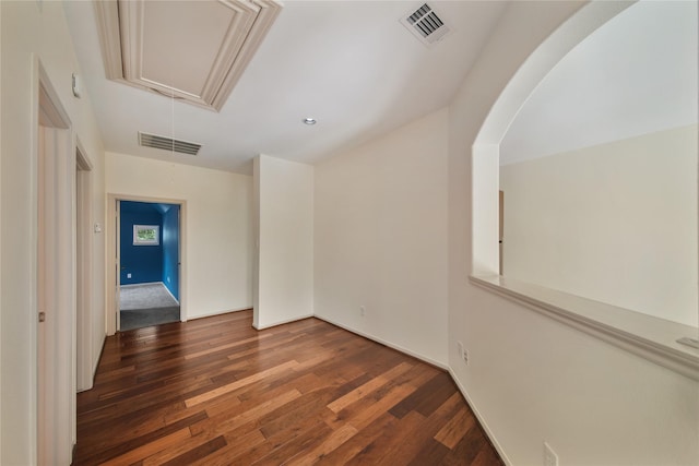 unfurnished room featuring attic access, wood finished floors, and visible vents