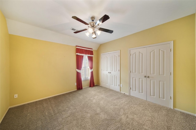 unfurnished bedroom featuring visible vents, carpet floors, two closets, baseboards, and ceiling fan