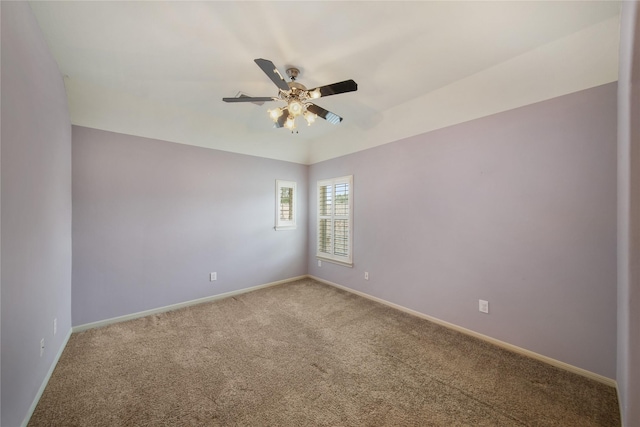 spare room with carpet floors, a ceiling fan, and baseboards