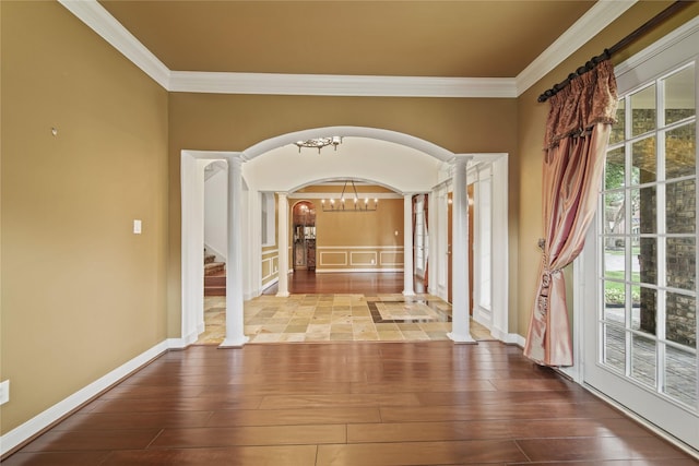 hallway featuring crown molding, arched walkways, ornate columns, and hardwood / wood-style floors