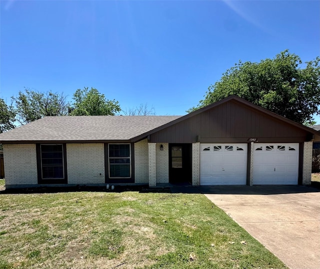 ranch-style home with driveway, a shingled roof, a front yard, an attached garage, and brick siding