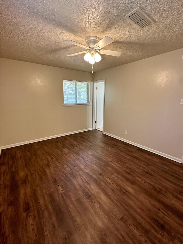 unfurnished room featuring dark wood finished floors, visible vents, a ceiling fan, and a textured ceiling
