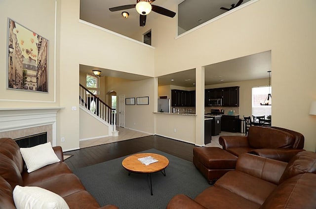 5002 Hearth Hollow Ln, Sugar Land, TX 77479 - living room featuring stairs, wood finished floors, a fireplace, arched walkways, and a ceiling fan