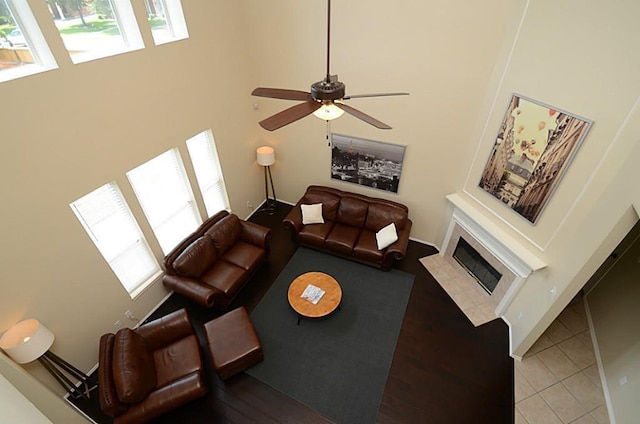 5002 Hearth Hollow Ln, Sugar Land, TX 77479 - living area featuring a ceiling fan, a high ceiling, a fireplace with flush hearth, and tile patterned floors