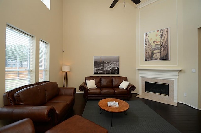 5002 Hearth Hollow Ln, Sugar Land, TX 77479 - living area with a tiled fireplace, a ceiling fan, baseboards, wood finished floors, and a towering ceiling