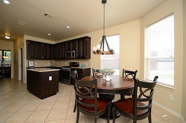 5002 Hearth Hollow Ln, Sugar Land, TX 77479 - kitchen with appliances with stainless steel finishes, an inviting chandelier, decorative backsplash, a kitchen island, and visible vents