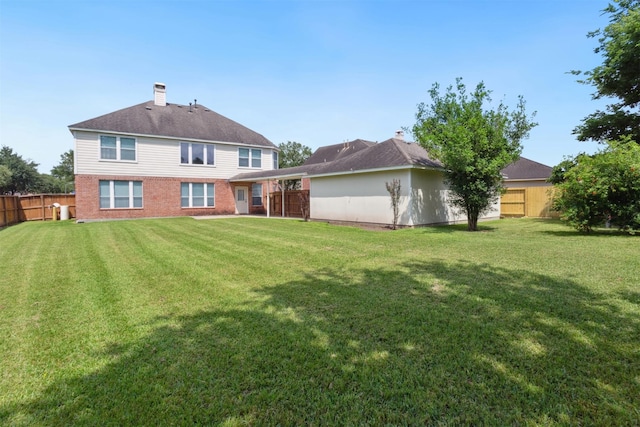 5002 Hearth Hollow Ln, Sugar Land, TX 77479 - back of house with a yard, brick siding, fence, and a chimney