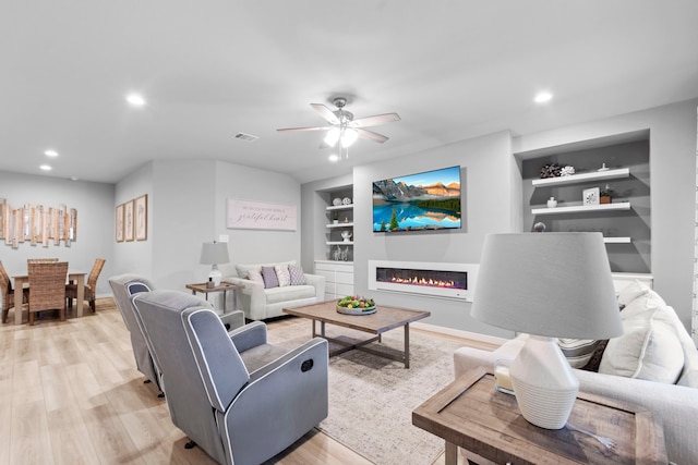 13532 Bonita Island Way, Texas City, TX 77568 - living room featuring built in features, light wood-style flooring, a ceiling fan, a glass covered fireplace, and recessed lighting