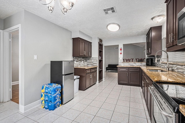 13126 Birch Grove Dr, Houston, TX 77099 - kitchen featuring a sink, stainless steel appliances, tasteful backsplash, dark brown cabinetry, and visible vents