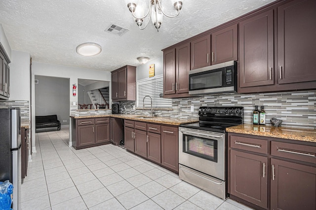 13126 Birch Grove Dr, Houston, TX 77099 - kitchen with a sink, decorative backsplash, stainless steel appliances, light tile patterned floors, and visible vents