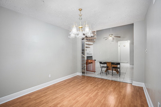 13126 Birch Grove Dr, Houston, TX 77099 - dining room featuring a textured ceiling, baseboards, wood finished floors, and ceiling fan with notable chandelier