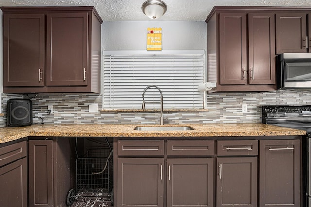 13126 Birch Grove Dr, Houston, TX 77099 - kitchen featuring stainless steel microwave, a sink, tasteful backsplash, dark brown cabinets, and electric range