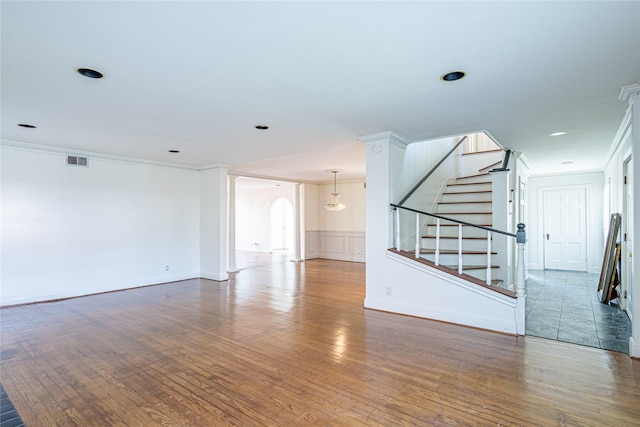 3210 Oakdale St, Houston, TX 77004 - unfurnished living room featuring ornamental molding, arched walkways, visible vents, and wood finished floors