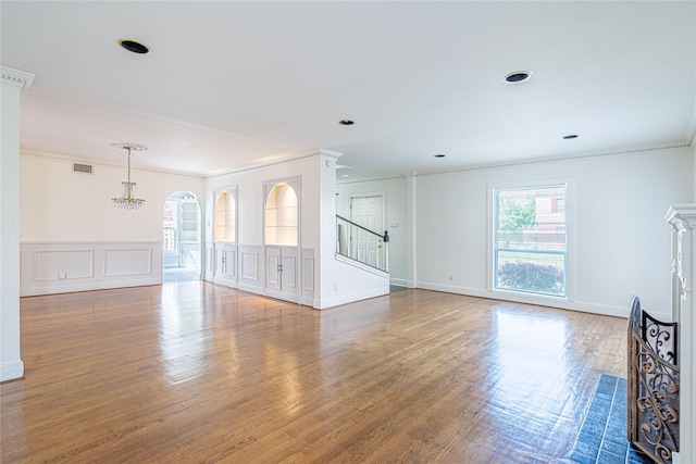3210 Oakdale St, Houston, TX 77004 - unfurnished living room with stairway, visible vents, ornamental molding, arched walkways, and wood finished floors