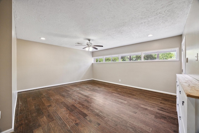 unfurnished room featuring baseboards, a ceiling fan, a textured ceiling, and dark wood-type flooring
