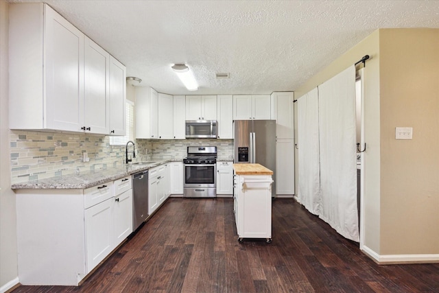 kitchen featuring white cabinets, stainless steel appliances, dark wood-style flooring, decorative backsplash, and wooden counters