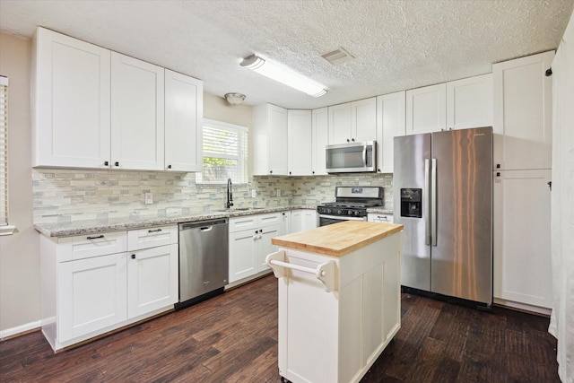 kitchen featuring wood counters, dark wood-style floors, a sink, and appliances with stainless steel finishes