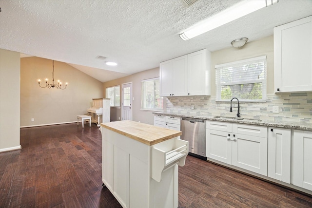 kitchen with stainless steel dishwasher, butcher block countertops, a sink, dark wood finished floors, and backsplash