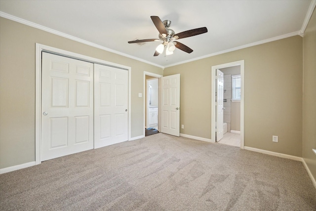 unfurnished bedroom with a closet, light carpet, baseboards, ornamental molding, and ensuite bathroom