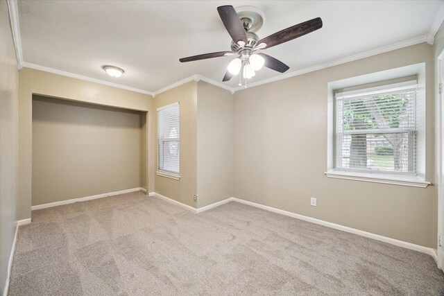 empty room featuring crown molding, carpet floors, and baseboards
