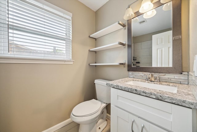 bathroom with visible vents, toilet, baseboards, and vanity