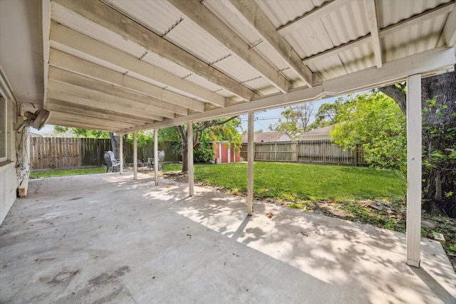 view of patio / terrace featuring a storage unit, an outbuilding, and a fenced backyard
