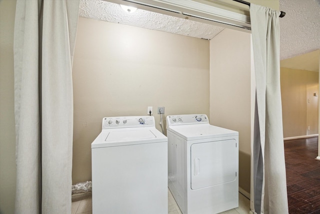 laundry area featuring a textured ceiling, washing machine and clothes dryer, and laundry area
