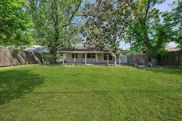 back of property featuring a yard and a fenced backyard