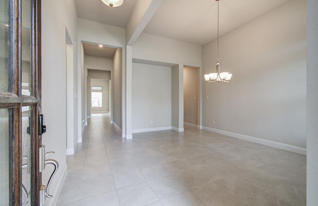 entryway featuring light tile patterned floors, a notable chandelier, and baseboards