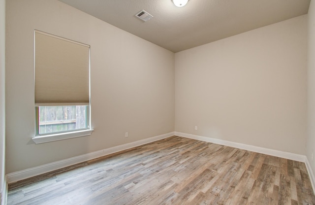 spare room with visible vents, baseboards, and light wood-type flooring
