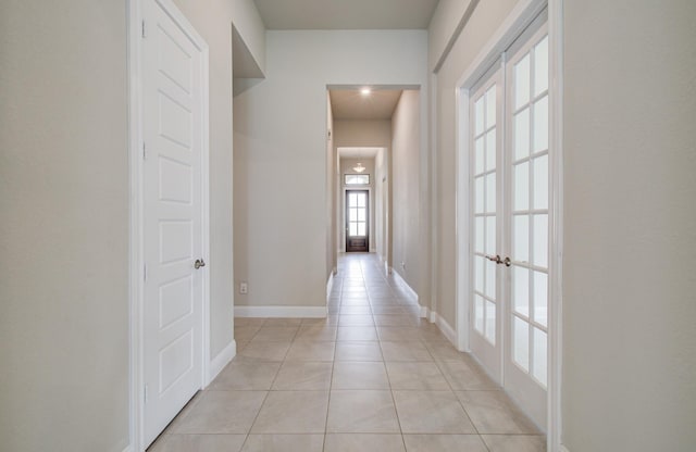 hall with baseboards and light tile patterned floors