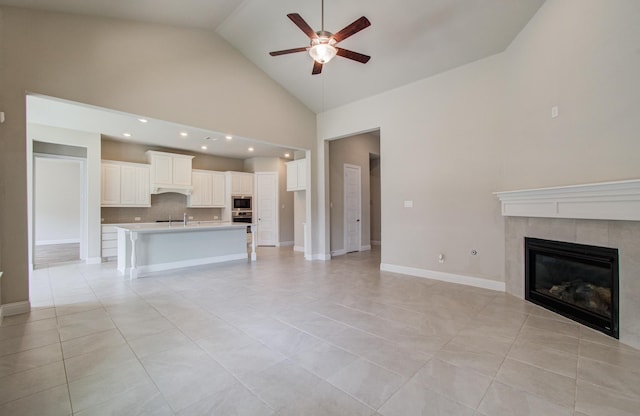 unfurnished living room with recessed lighting, a tile fireplace, light tile patterned floors, high vaulted ceiling, and ceiling fan