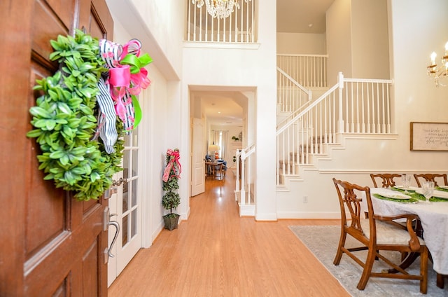 1615 Lakeside Enclave Dr, Houston, TX 77077 - foyer featuring a chandelier, stairway, a towering ceiling, light wood-style floors, and baseboards