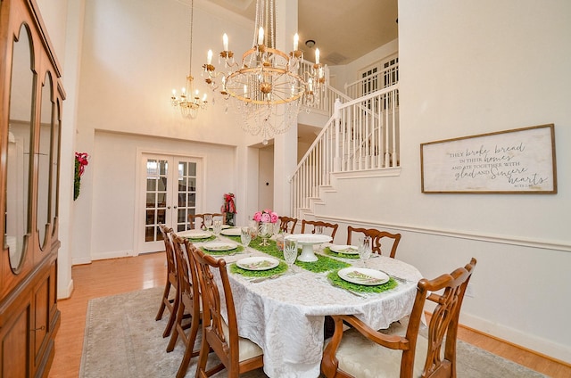 1615 Lakeside Enclave Dr, Houston, TX 77077 - dining area featuring french doors, a chandelier, a towering ceiling, light wood-type flooring, and baseboards