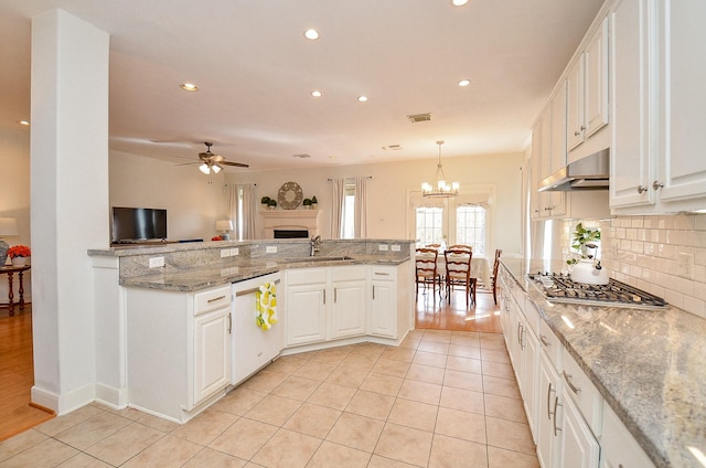 1615 Lakeside Enclave Dr, Houston, TX 77077 - kitchen with dishwasher, stainless steel gas stovetop, a sink, under cabinet range hood, and a fireplace