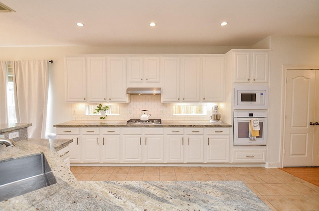 1615 Lakeside Enclave Dr, Houston, TX 77077 - kitchen with white appliances, ventilation hood, a sink, light tile patterned flooring, and recessed lighting