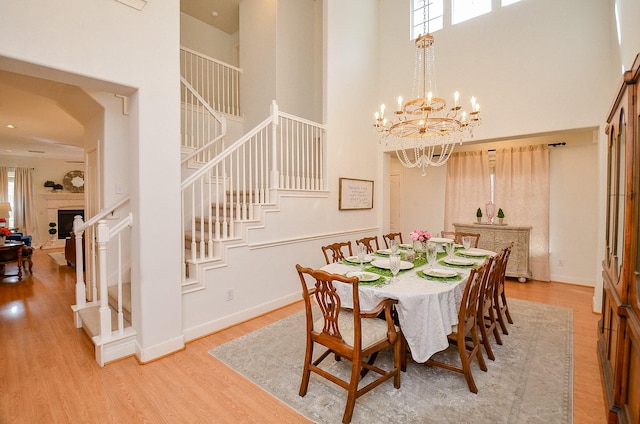 1615 Lakeside Enclave Dr, Houston, TX 77077 - dining space with a towering ceiling, stairway, wood finished floors, a chandelier, and baseboards